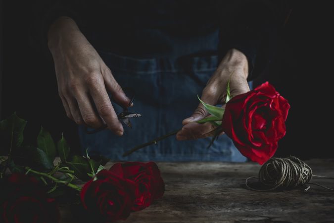 Unrecognizable woman making a bouquet of red roses