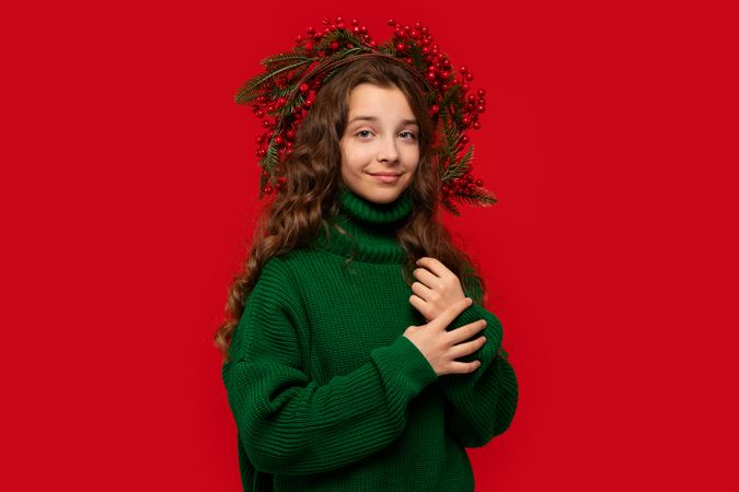 Teen girl in green sweater with Christmas berry wreath