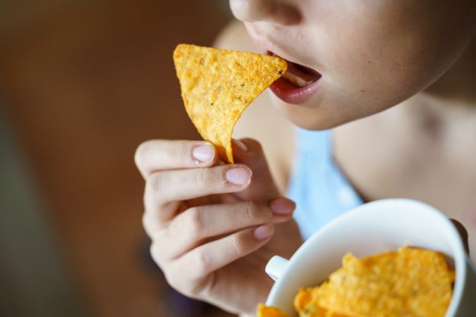 Girl biting into nacho chips