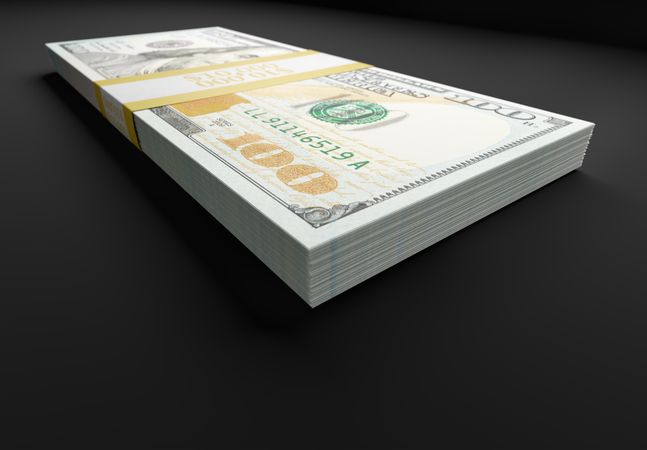 Stack of Ten Thousand Dollars of One Hundred Dollar Bills on Reflective Surface.