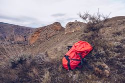 Bright backpack at mountain slope