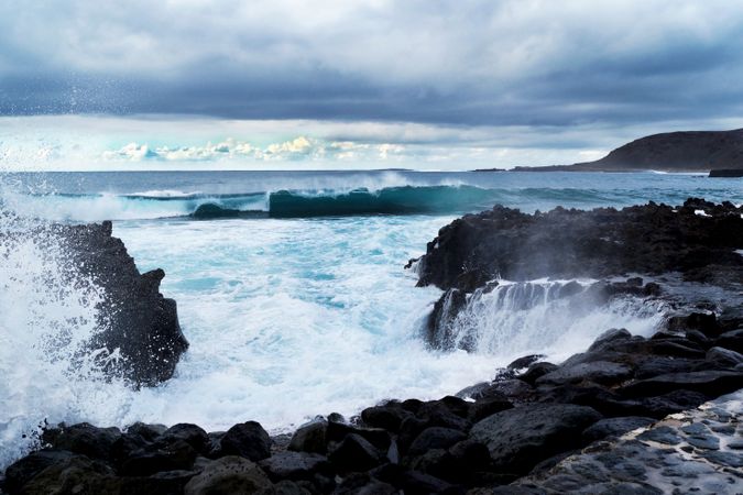 blue waves of ocean with foam texture against rocks