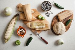 Dough near corn husk and spices for tamales