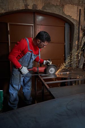 Metalsmith in protective clothing working with metal