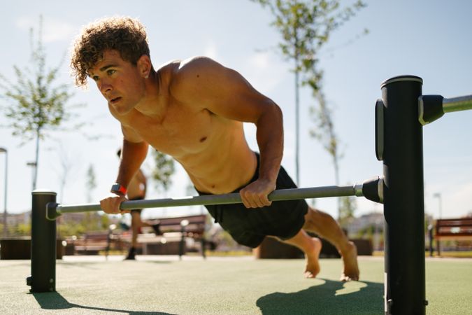 Strong young sportsman doing calisthenics