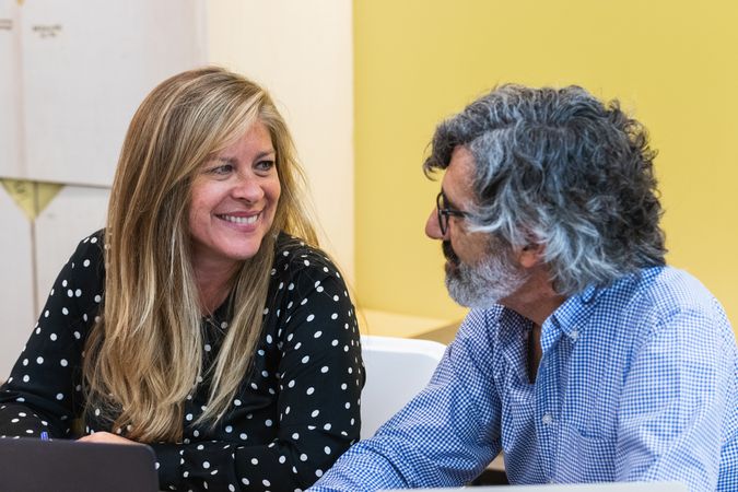 Cheerful coworkers working on laptop in office