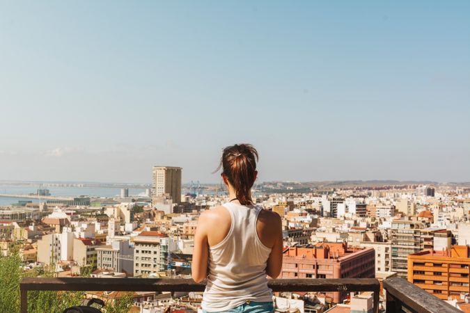 Woman on balcony looking at city views from above