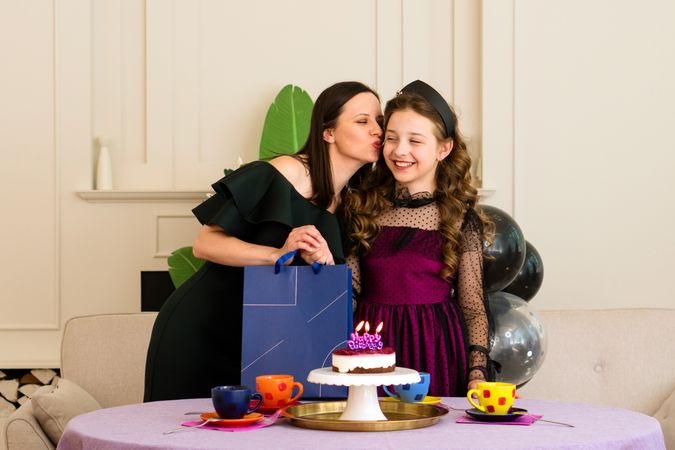 Mother kisses daughter on birthday