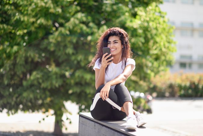 Arab woman talking on phone sitting outdoors