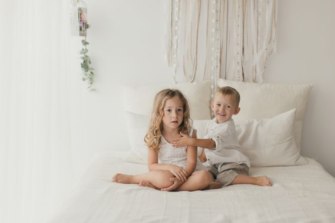 Sister embracing little brother at home
