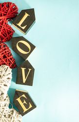 Word "love" on blue pastel table with thatched hearts