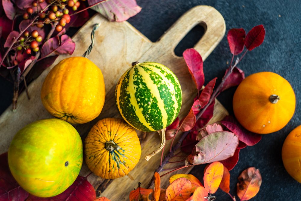 Autumn squash on breadboard with leaves