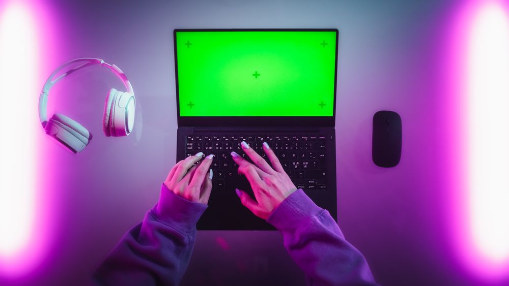 Top Down Shot of a Female Software Developer Working on a Laptop in Stylish Room with Neon Lights. Computer with Green Screen Chroma Key Template for Digital Marketing Services, Apps, Software