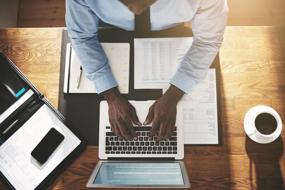 Overhead shot of man in suit and tie working on his laptop