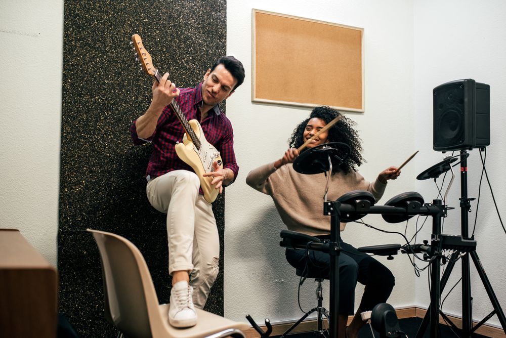 Man playing guitar and woman playing drums
