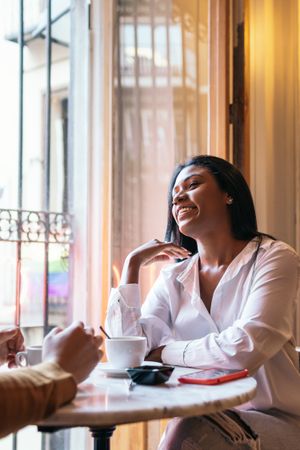 Close-up of a smiling Black Latina woman in a coffee shop