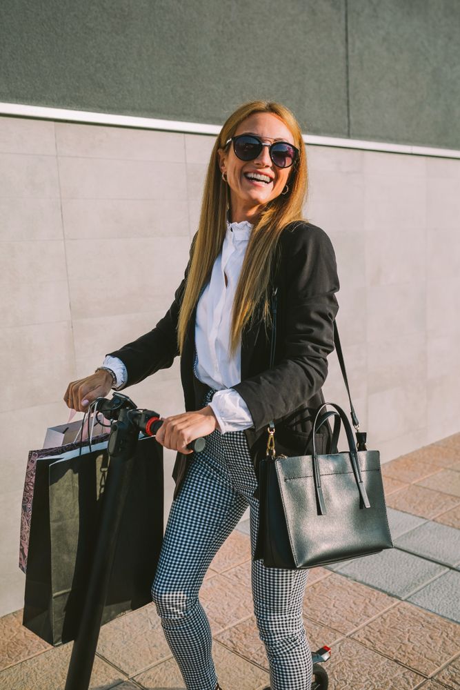 Woman with shopping bags on electric scooter