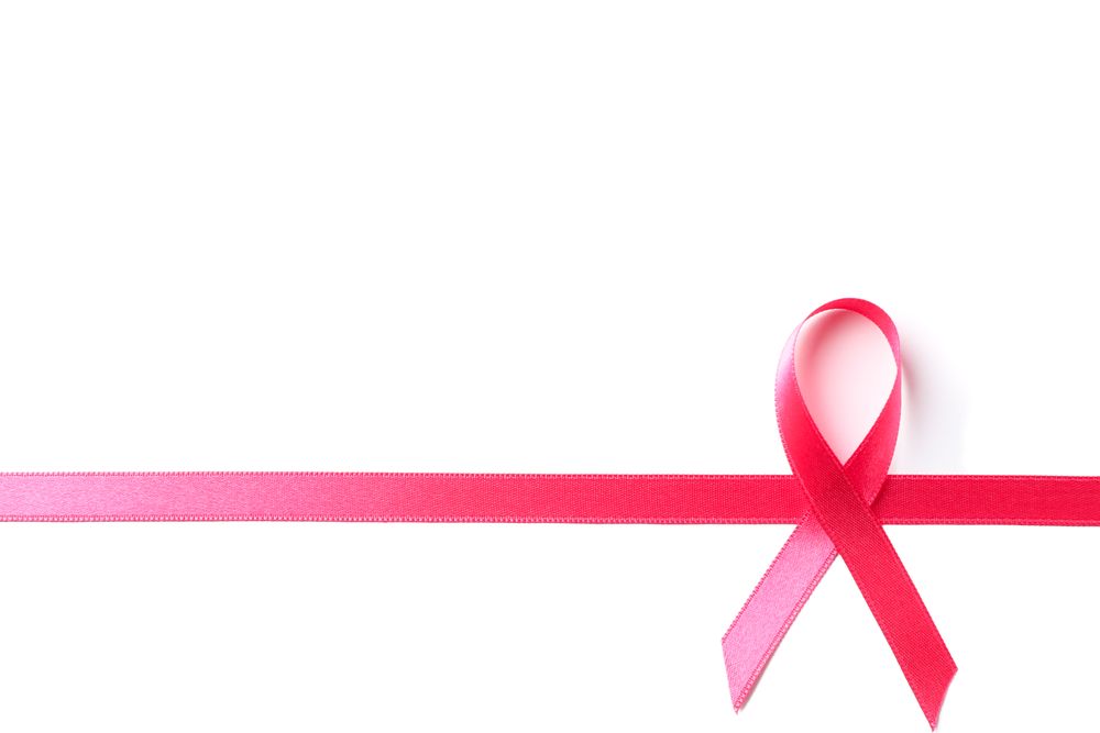 Pink awareness ribbon isolated on blank background, top view