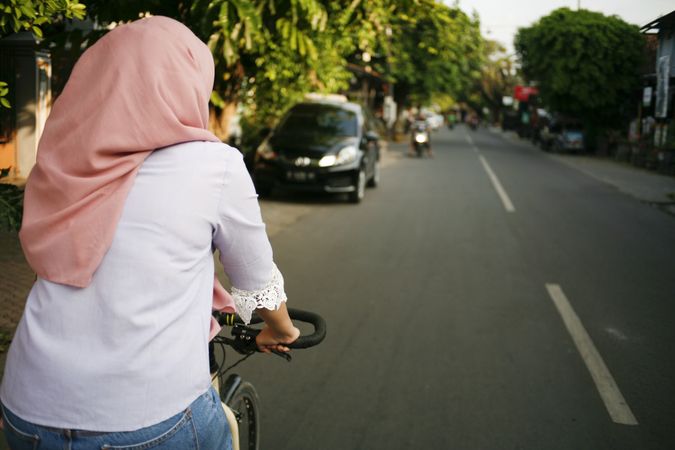Woman on bike in Indonesia with copy space