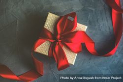 Single gift box with red ribbon on concrete 5a2ko4