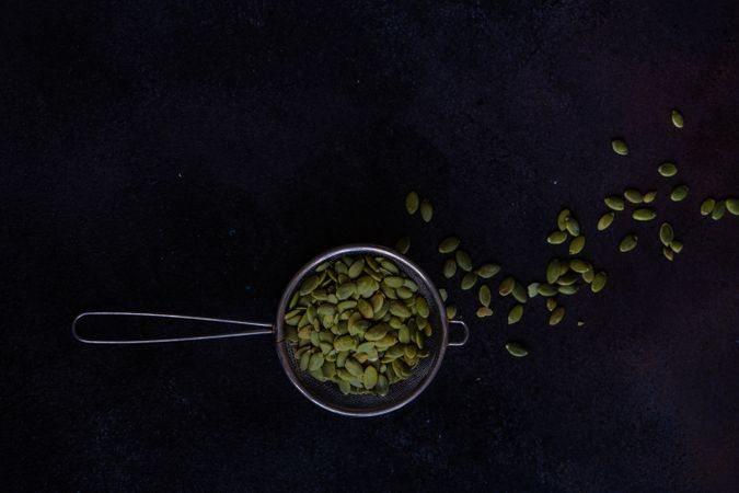 Measurement spoon filled with pumpkin seeds