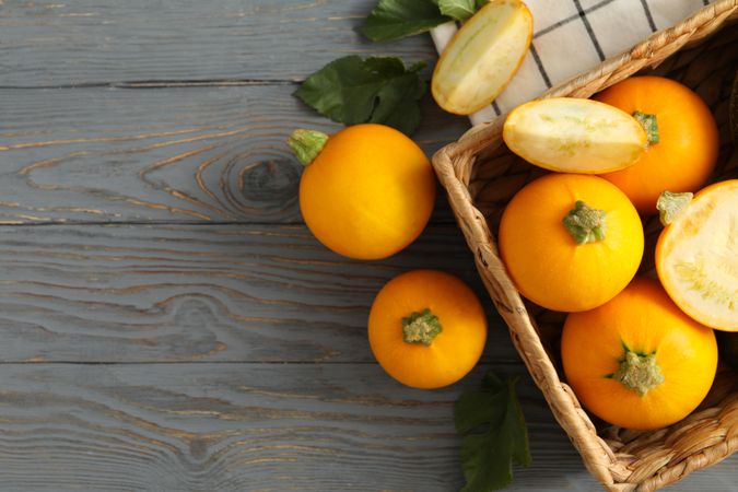 Basket with zucchini on napkin on wooden table