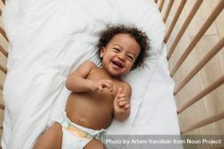 Cute and happy baby boy in his crib 498oa5