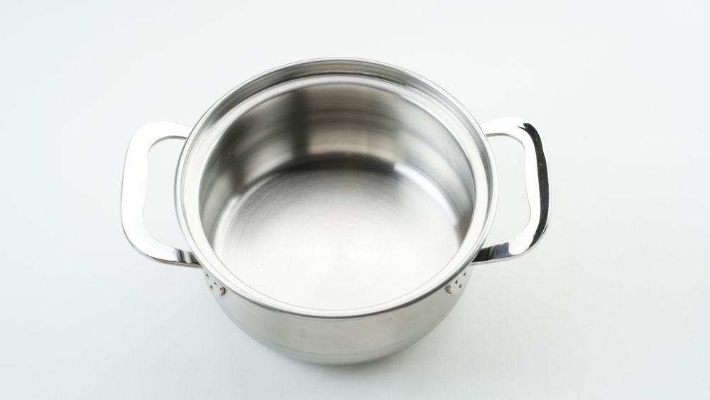 Stainless steel cooking pot on light background
