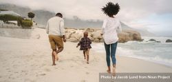 Family running on beach bDYZV0