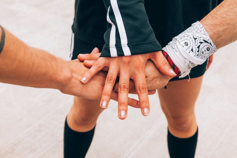 Group of young people putting hands together
