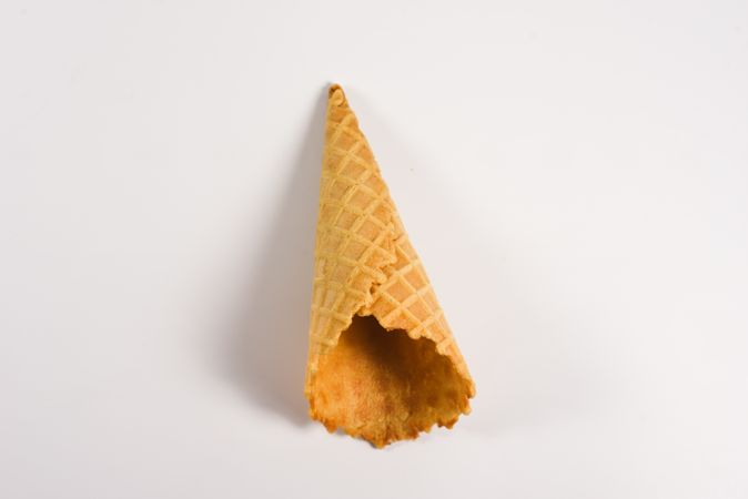 Top view of empty waffle cone lying on plain table