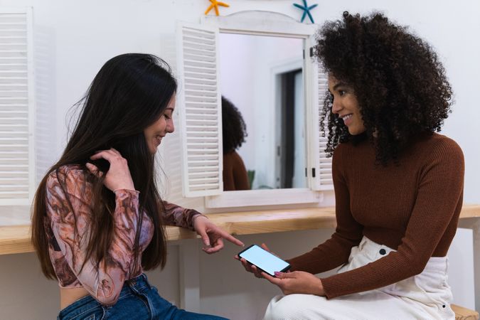 Happy multiracial women chilling together in bar