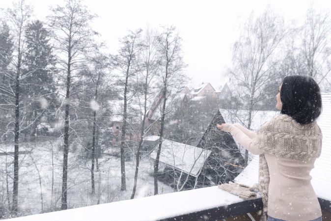 Woman catching snowflakes with both hands