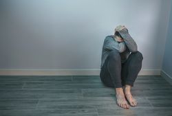 Unrecognizable man with problems sitting on floor