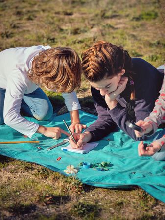 Focused teen children exploring assorted garbage and plastic was