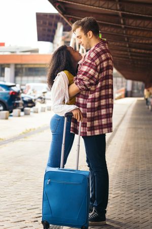 Young happy couple meeting at the station after a trip