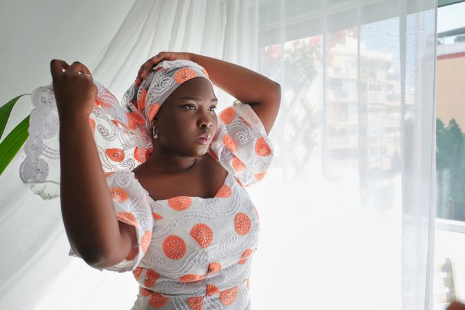 Black woman putting kerchief on head