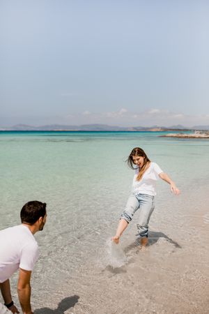Cheerful lovers having fun on tropical coastline