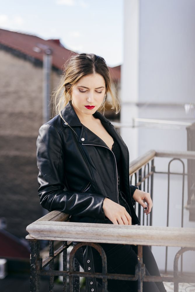 Stylish female standing on apartment balcony