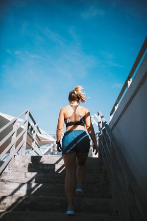 Young woman exercising on stadium stairs