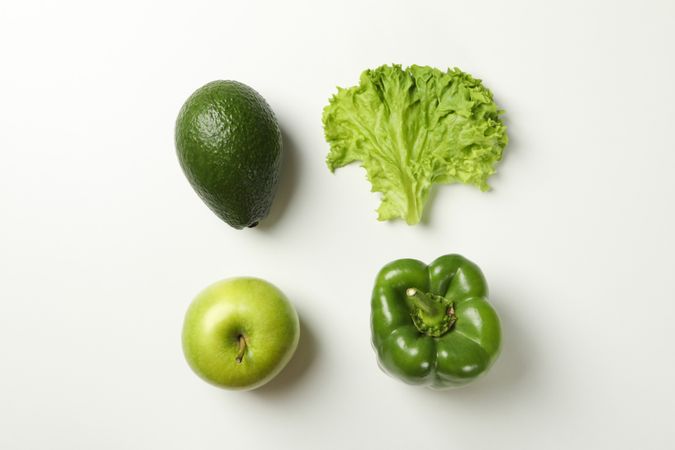 Avocado, apple, salad and pepper on blank background