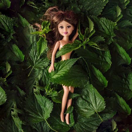 Brunette doll wrapped in nettle leaves