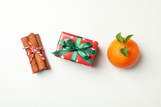 Mandarin, cinnamon and gift box on light background