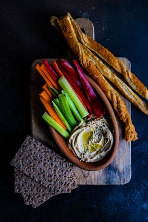 Traditional hummus spread with carrots, celery and breadsticks to dip