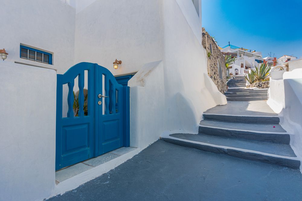 Blue gate next to a walkway in Santorini
