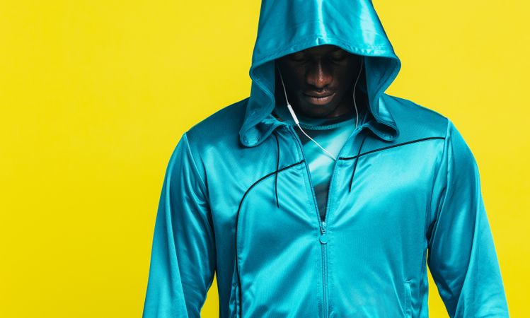 Black man in a hoodie on yellow background