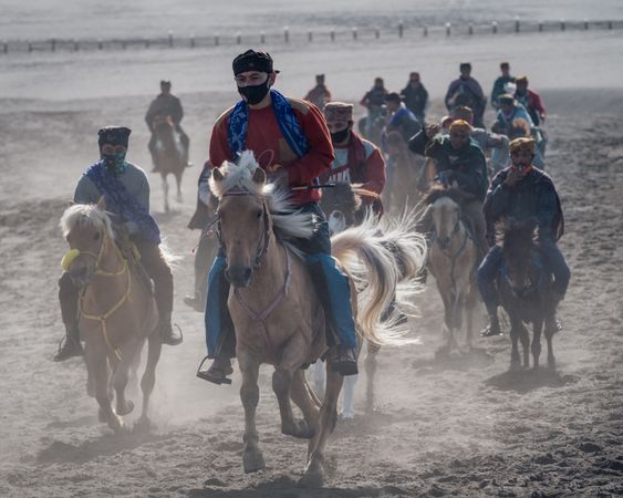 Group of men from The Tengger tribe riding horses in Bromo National Park in East Java, Indonesia