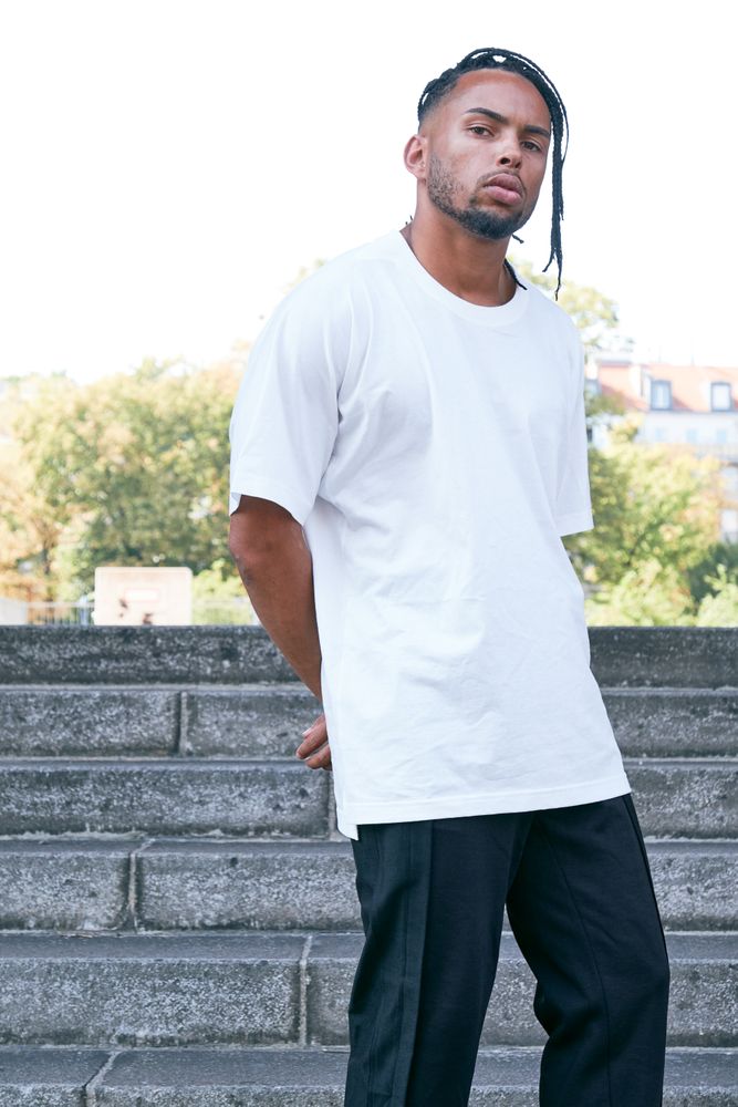 Trendy Black man posing near modern arch