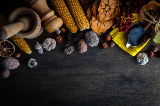 Thanksgiving day or autumnal harvest flatlay with nuts, berries, vegetable and fruits on dark wooden background with copy space