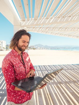Man using laptop on beach